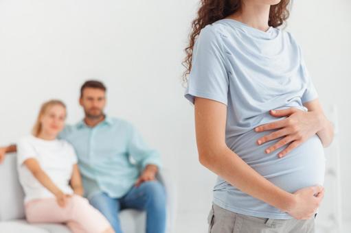 お腹を触る妊婦と後ろに座る妊婦 お腹を触る妊婦と後ろに座る妊婦の写真