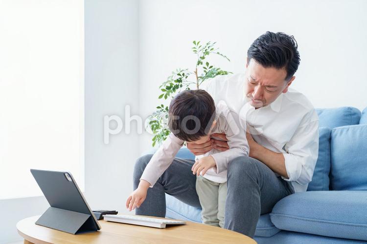 テレワークする父親を邪魔する子ども  ビジネスマン,子供,いたずらの写真素材