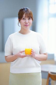 微笑みオレンジジュースを持つ女性 女性,飲み物,コップの写真素材