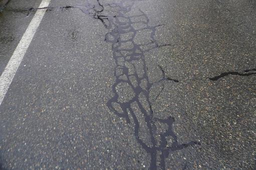 アスファルトのヒビ割れ補修（雨）04 アスファルト,道路,ヒビ割れの写真素材