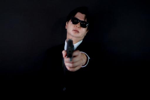 黒いスーツの男性と銃 黒いスーツの男性と銃 男性,スーツ,銃の写真素材