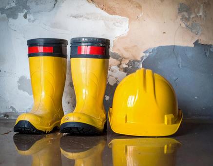 黄色い作業用の長靴とヘルメットの写真