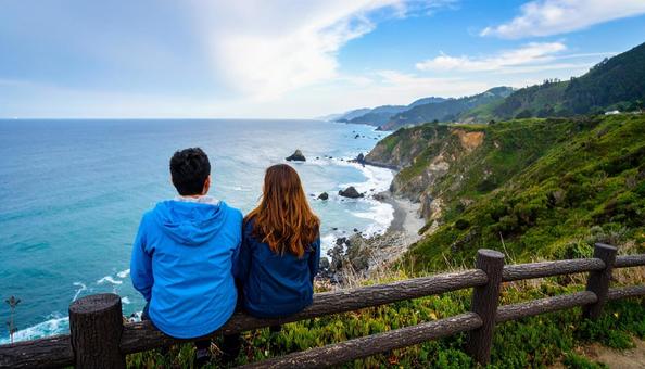 海辺に座るカップルの写真
