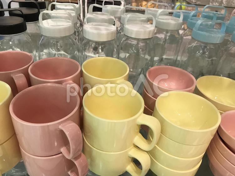 ピンクとイエローのカラフルなマグカップとビンの陳列 カップ,コーヒーカップ,カラフルの写真素材