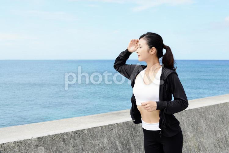 海岸でジョギングを楽しむ女性 女性,女,運動の写真素材