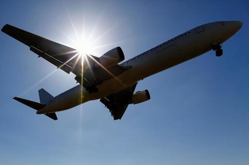 太陽｜青空｜着陸飛行機 飛行機,航空機,旅客機の写真素材