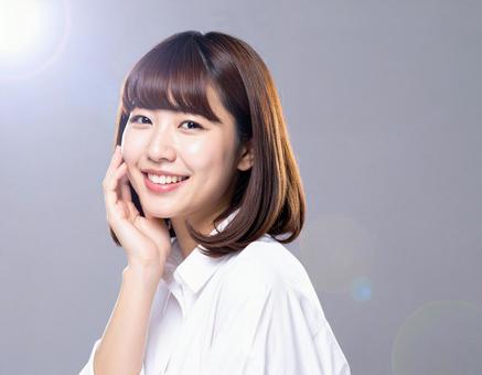 頬に手を当てて微笑む女性 頬に手を当てて微笑む女性の写真
