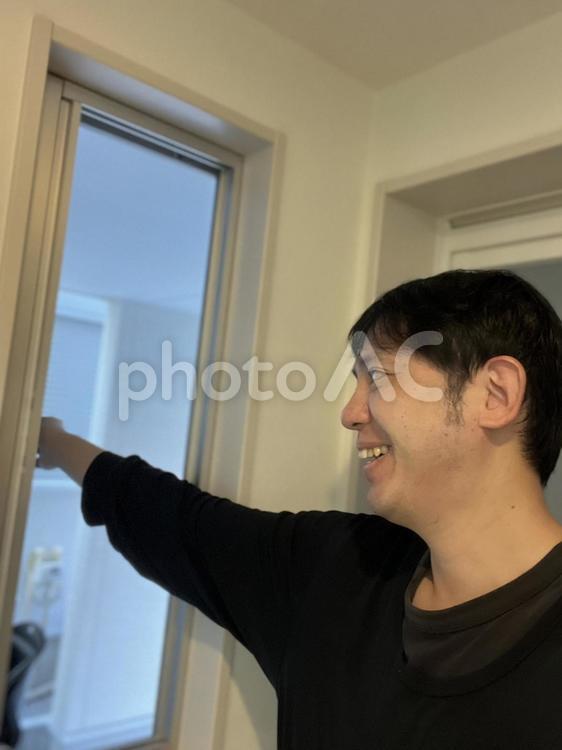 笑顔で窓を開ける男性　1 男性,窓,開けるの写真素材