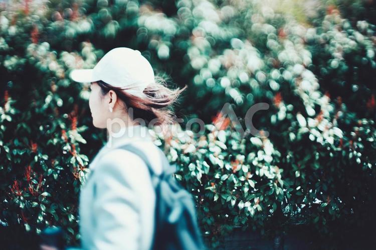 歩く女性の横顔と緑ぼかし背景 女性,人物,歩くの写真素材