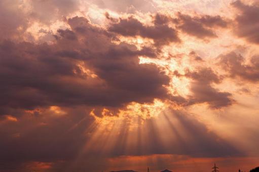 夕暮れ時の雲の間から漏れる夕日の光芒 夕暮れ時の雲の間から漏れる夕日の光芒 空,雲,夕焼けの写真素材