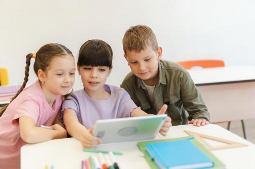 微笑んでタブレットを見る生徒たち 男の子,女の子,子どもの写真素材