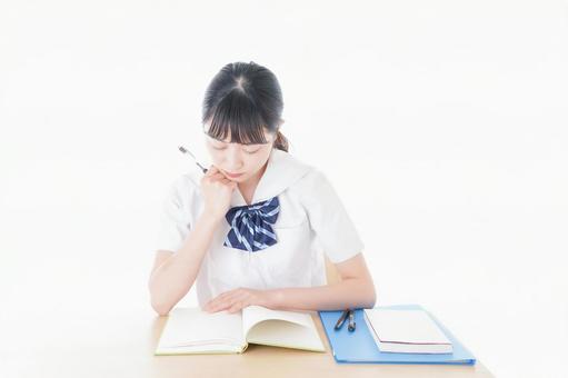 A female student in uniform studying at a desk, JPG