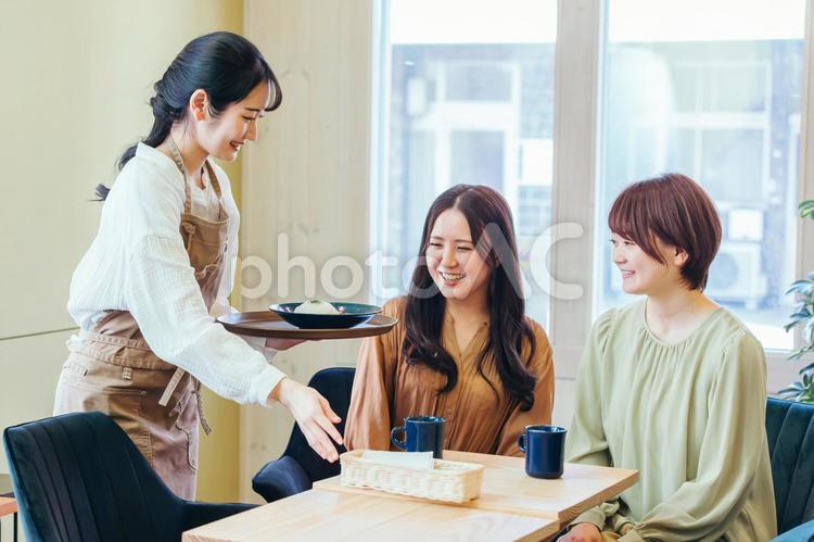 ランチを食べる客とカフェスタッフ ランチ,レストラン,カフェの写真素材