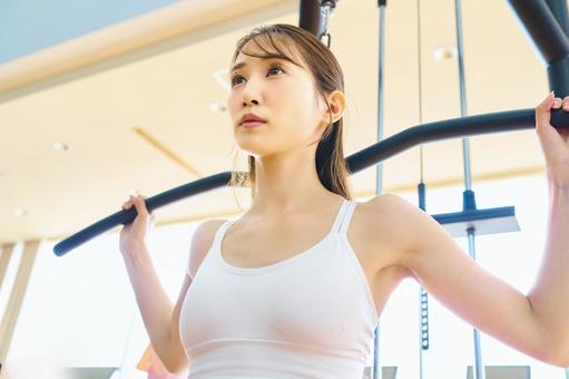スポーツジムのマシンで筋トレする女性 トレーニング,女性,フィットネスの写真素材