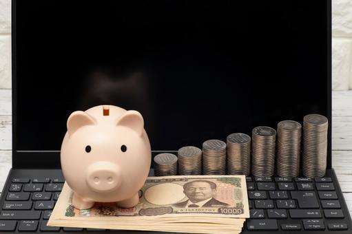 ノートパソコンと豚の貯金箱と一万円札 お金,電卓,家計の写真素材