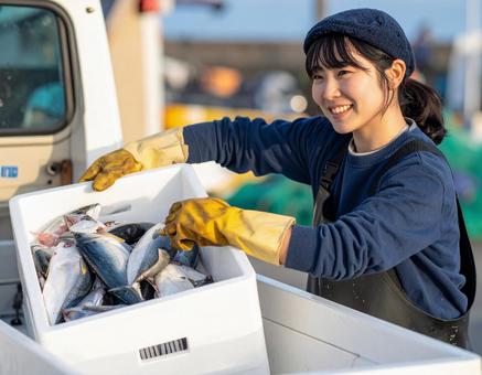 水揚げした魚介類を軽トラに積む漁師の女性 水揚げした魚介類を軽トラに積む漁師の女性の写真