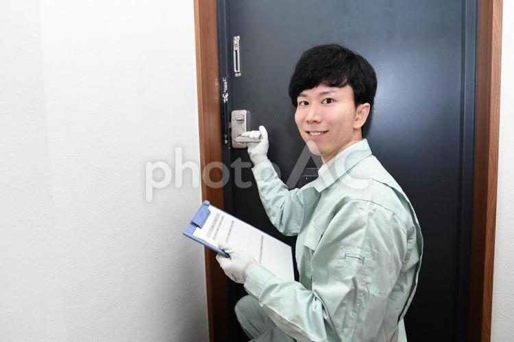 玄関扉(鍵)の修理・交換・調査する作業員 男性,ドア,玄関の写真素材