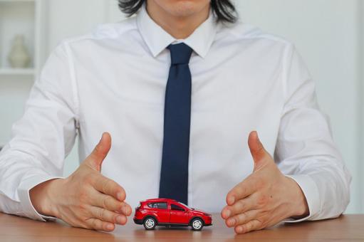 車の模型を守る男性の手元 保険業,事務職,接客業の写真素材