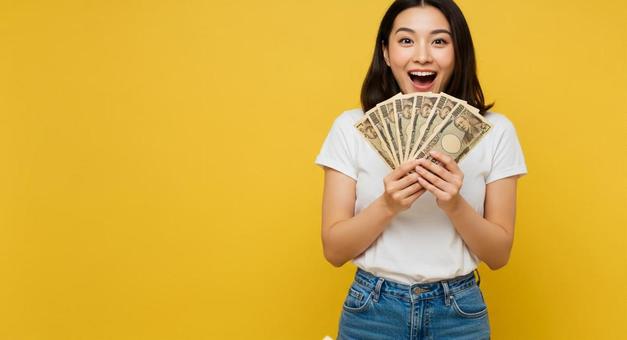 大金を手にして喜ぶ女性 大金を手にして喜ぶ女性の写真