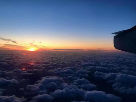 飛行機から見た夕暮れどきの雲の上 飛行機から見た夕暮れどきの雲の上 夕暮れ,夕日,日が沈むの写真素材