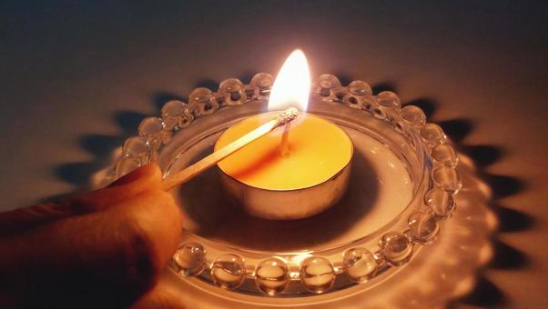 キャンドルにマッチで火をつけている写真 キャンドルにマッチで火をつけている写真 キャンドル,アロマキャンドル,火の写真素材