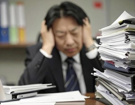 ビジネスマン 残業 山積み 書類 ビジネスマン 残業 山積み 書類の写真
