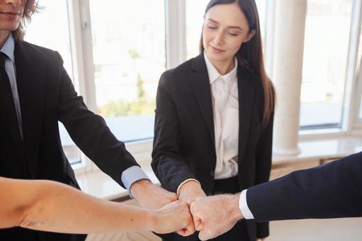 グータッチをする手元と見る女性の写真