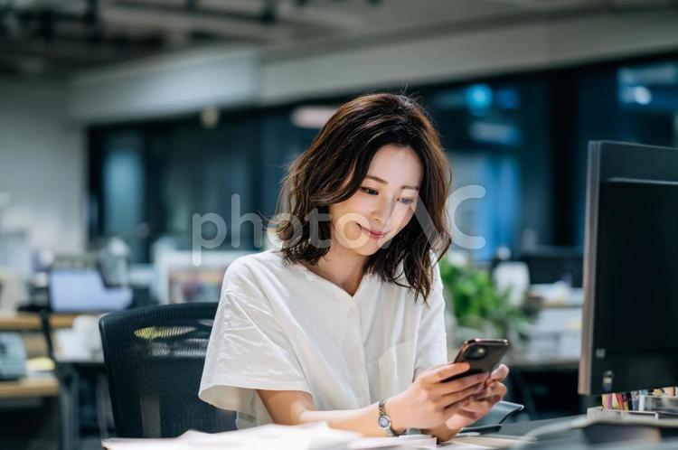 オフィスでスマホを見る女性-3 オフィス,スマホ,女性の写真素材