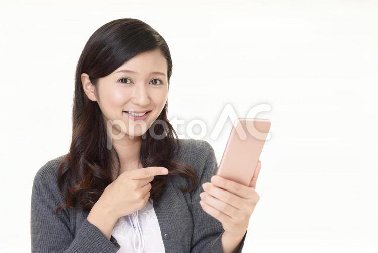 スマートフォンを持つ笑顔の女性 女性,スマートフォン,女の写真素材