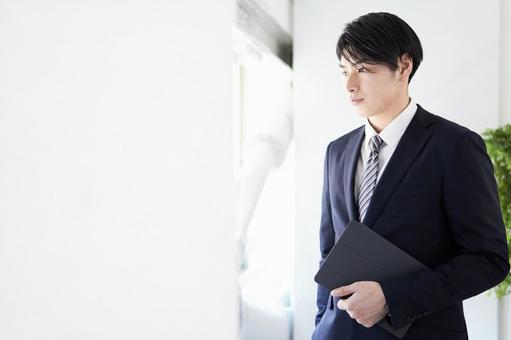 Japanese male businessman looking out the window with a serious expression, business, male, businessman, JPG