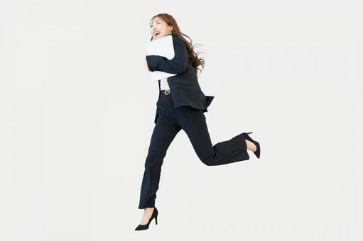 パソコンを持って走る女性（全身） 女性,パソコン,走るの写真素材