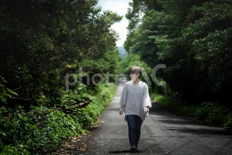 ＜素材＞新緑の初夏の山道を散歩する女性 女性,道路,新緑の写真素材