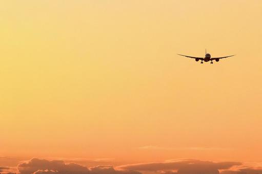朝焼け空に着陸する飛行機シルエット 朝焼け空に着陸する飛行機シルエットの写真