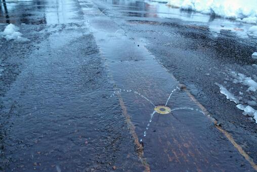 雪の残る車道と消雪パイプから出る地下水 消雪パイプ,融雪,車道の写真素材