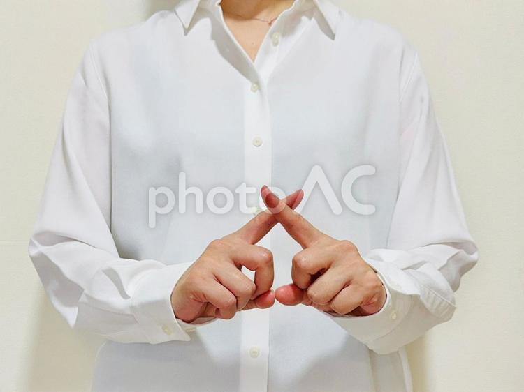 指でバッテンマークをする白シャツの女性 バツ,ダメ,禁止の写真素材