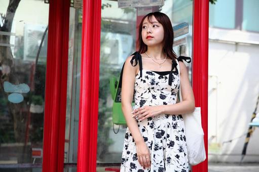 電話ボックスの前で人待ち顔の女性 電話ボックスの前で人待ち顔の女性の写真