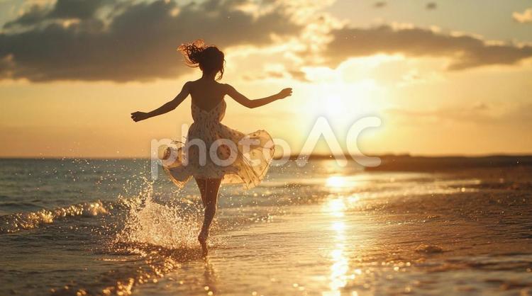 夕暮れの海を歩く女性の後ろ姿② 夏,夕焼け,海の写真素材