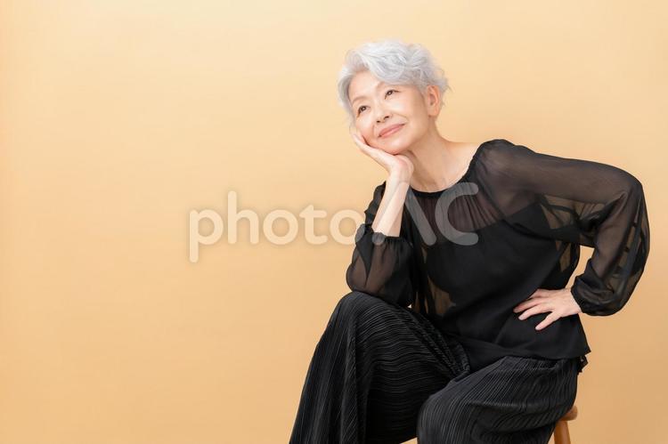 ベージュバックでスキンケアをするシニア ビューティー,女性,シニアの写真素材