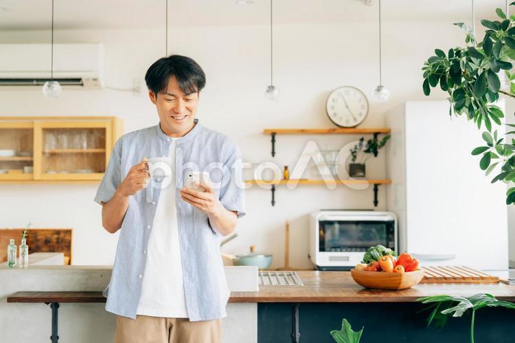 家でスマホを使う男性（アプリ） スマホ,男性,スマートフォンの写真素材