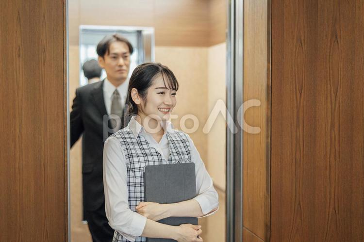 エレベーターから降りるビジネスマンとOL エレベーター,オフィス,会社の写真素材