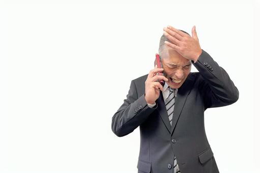 電話の対応でおでこを押さえる中年男性 電話,ビジネス,男性の写真素材