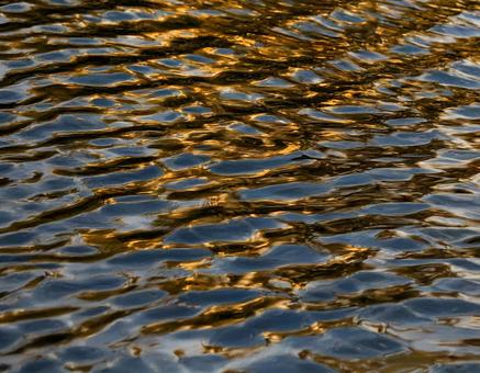 秋の湖に映る紅葉と水面の反射1の写真
