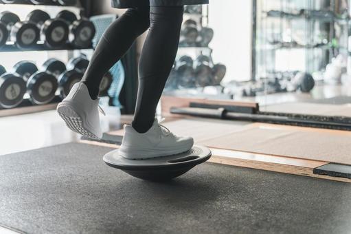 バランスボードで体幹トレーニングする男性 バランスボード,フィジカルトレーニング,ボードタイプの写真素材
