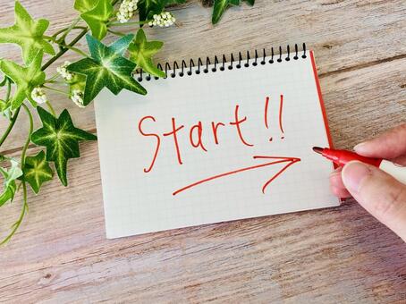 英語でスタートの文字と矢印を書く手元 スタート,はじめる,はじまるの写真素材