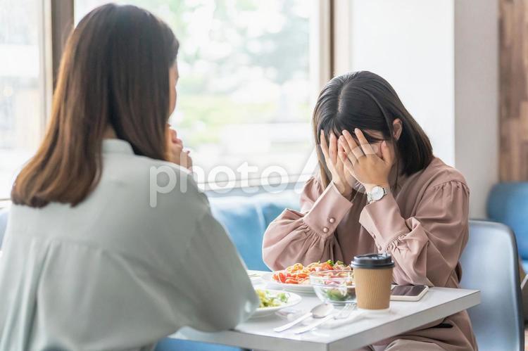 カフェで同僚・友達の前で泣く女性（相談） 相談,悩み,別れ話の写真素材