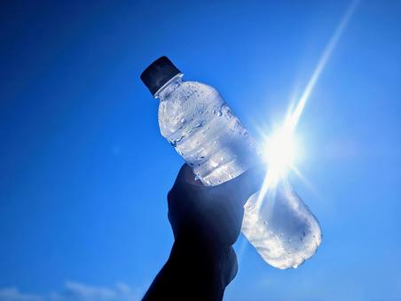 ペットボトルに入った水と空と太陽 ペットボトルに入った水と空と太陽の写真