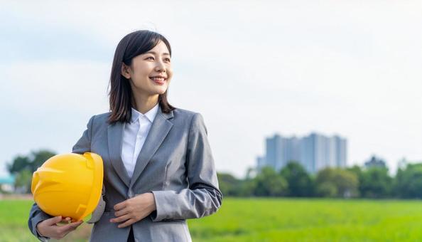 ヘルメットを抱え笑顔の若い日本人女性の写真