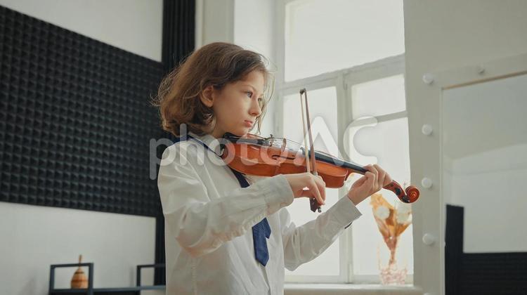 窓辺で演奏する女の子の横顔 バイオリン,女の子,ショートカットヘアの写真素材