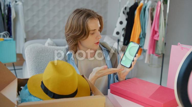 携帯を見ながら説明する男性 男性,人物,携帯の写真素材