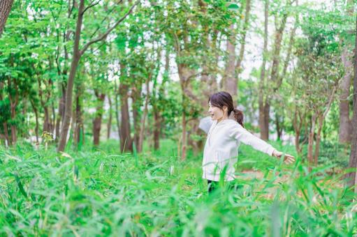 自然を散策する若い女性 マイナスイオン,深呼吸,森林浴の写真素材